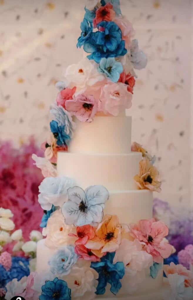 Elegant wedding cake in Tuscany adorned with vibrant wafer paper flowers, capturing the romantic essence of a Tuscan wedding celebration.